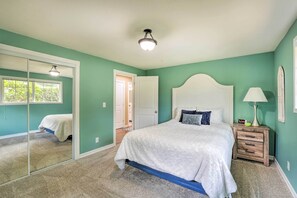 Une chambre à coucher avec un lit, une table de chevet, une lampe et un miroir.