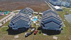 A beachfront hotel with two-story buildings, a swimming pool, and a beach view. - Pool w/ Spa! Beachfront Condo in Port Aransas (Port Aransas)