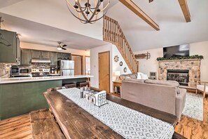 A modern kitchen with a central island, a dining area with a wooden table, and a living room with a fireplace. - Walk to Arrowhead Lake: Cabin w/ Private Hot Tub! (Pocono Lake)