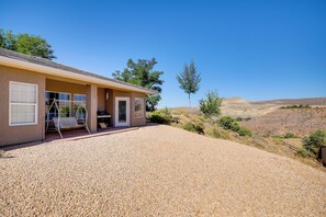 A house with a gravel driveway, a swing chair outside, and a view of a hilly landscape. - Family-friendly Home Near Zion National Park! (La Verkin)