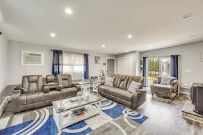 A modern living room with a sectional sofa, a coffee table, and a TV. - Waterfront Wallkill Duplex Home w/ Fire Pits! (Wallkill)