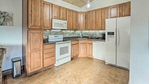 A kitchen with wooden cabinets, a white refrigerator, a microwave, a stove, and a dishwasher. - Equestrian Escape! Quiet Farm Stay Near Gettysburg (Union Bridge)
