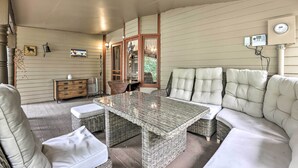 A cozy indoor seating area with wicker furniture, a cushioned sofa, and a wooden cabinet. - Family Home in Georgetown: Walk to Town & Railroad (Georgetown)