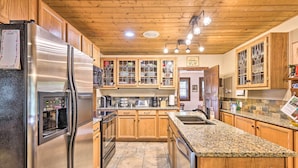 A kitchen with wooden cabinets, granite countertops, stainless steel appliances, and a wooden ceiling. - Family Home in Georgetown: Walk to Town & Railroad (Georgetown)