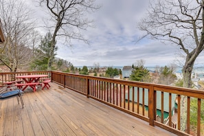 A wooden deck with picnic tables and chairs, overlooking a residential area and a body of water. - Family Friendly Mears Cottage - Walk to the Beach! (Mears)