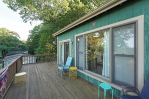 A wooden deck with a railing, a blue chair, and a yellow stool. - Family Friendly Mears Cottage - Walk to the Beach! (Mears)