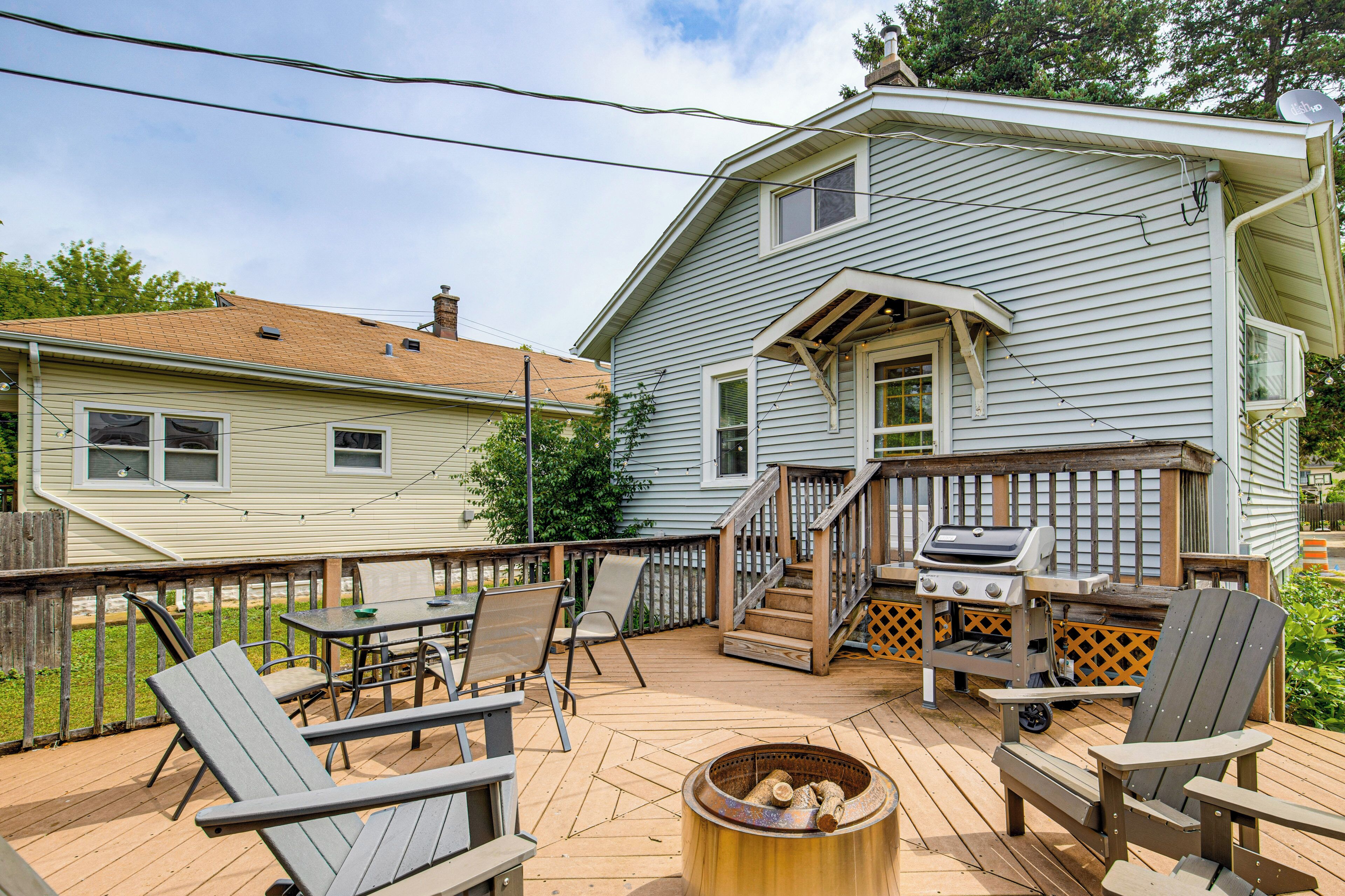 A deck with outdoor furniture, a grill, and a fire pit.