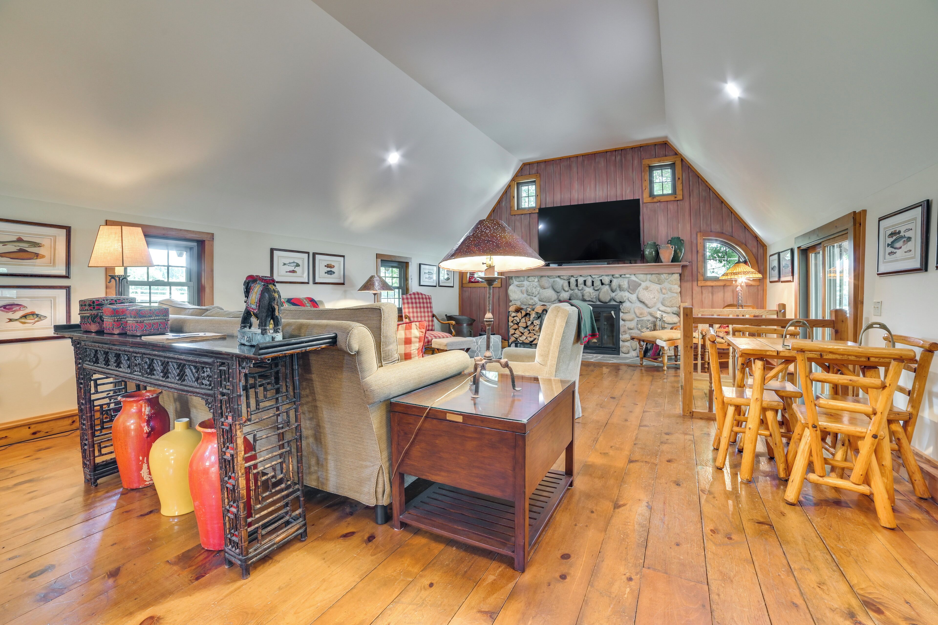 A spacious living area with a fireplace, wooden furniture, and a television.