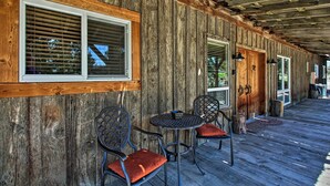 A wooden exterior with a covered porch, two tables with chairs, and a wooden door. - Dog-friendly Ranch Cottage w/ Yard ~ 13 Mi to Bend (Bend)