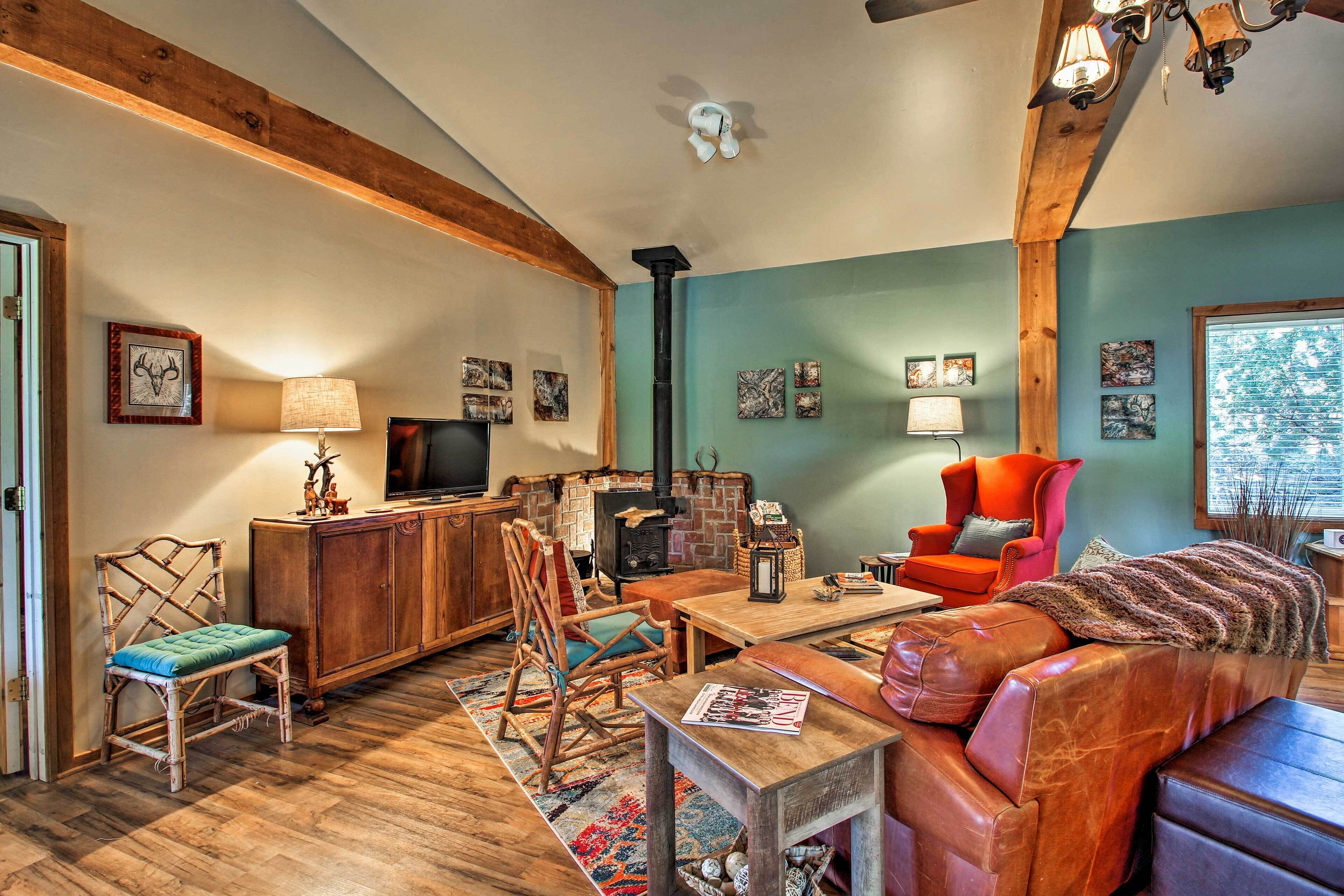 A cozy living room with a fireplace, wooden beams, and a comfortable seating area.
