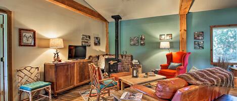 A cozy living room with a fireplace, wooden beams, and a comfortable seating area.