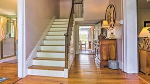 A staircase leading to a second floor, a wooden cabinet with a lamp, and a dining area with chairs and a table. - Historic 'hammond House' w/ Wine Country View! (Strasburg)