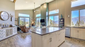 A spacious kitchen with a large island, wooden cabinets, and a dining area with chairs. - 'gorge Retreat' - Modern Carson Home w/ Mtn Views! (Carson)