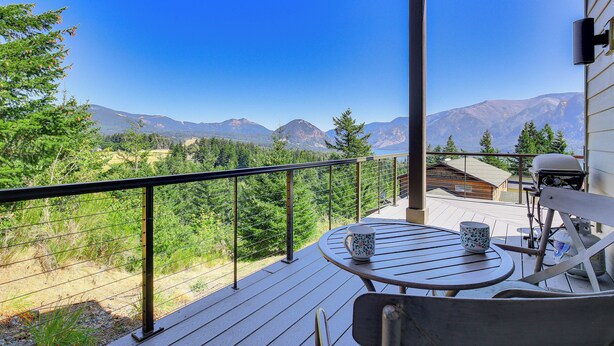 A balcony with a view of mountains, a table with a mug, and a grill. - 'gorge Retreat' - Modern Carson Home w/ Mtn Views! (Carson)