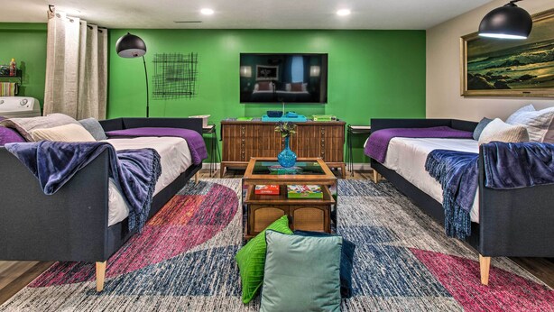 A modern room with two beds, a coffee table, and a TV.