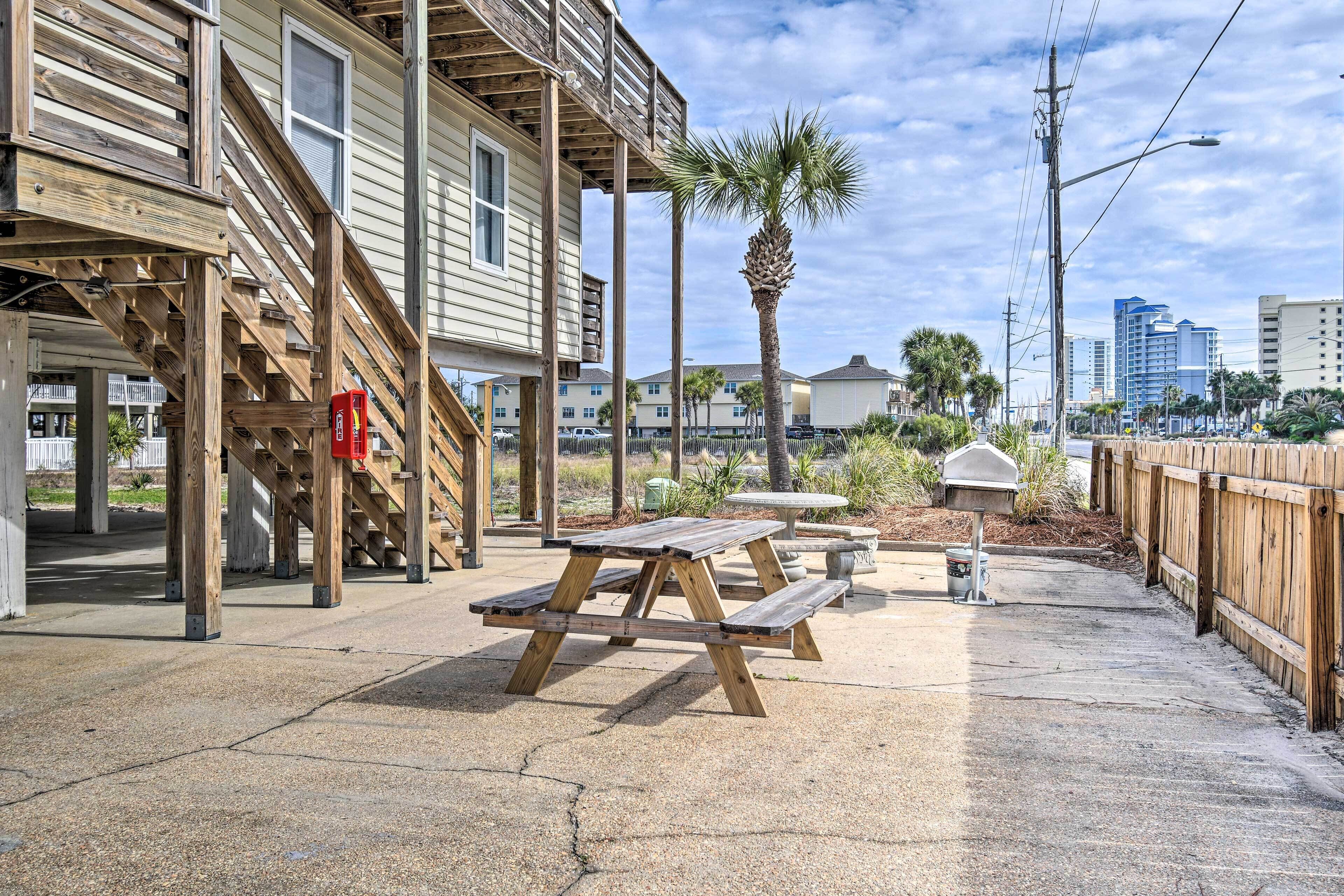 A wooden deck with picnic tables, a palm tree, and a mailbox.