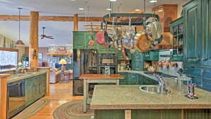 A kitchen with green cabinets, a granite countertop, and hanging pots. - 2 Mi to Skiing: Mtn-view Home w/ Deck in Granby! (Granby)