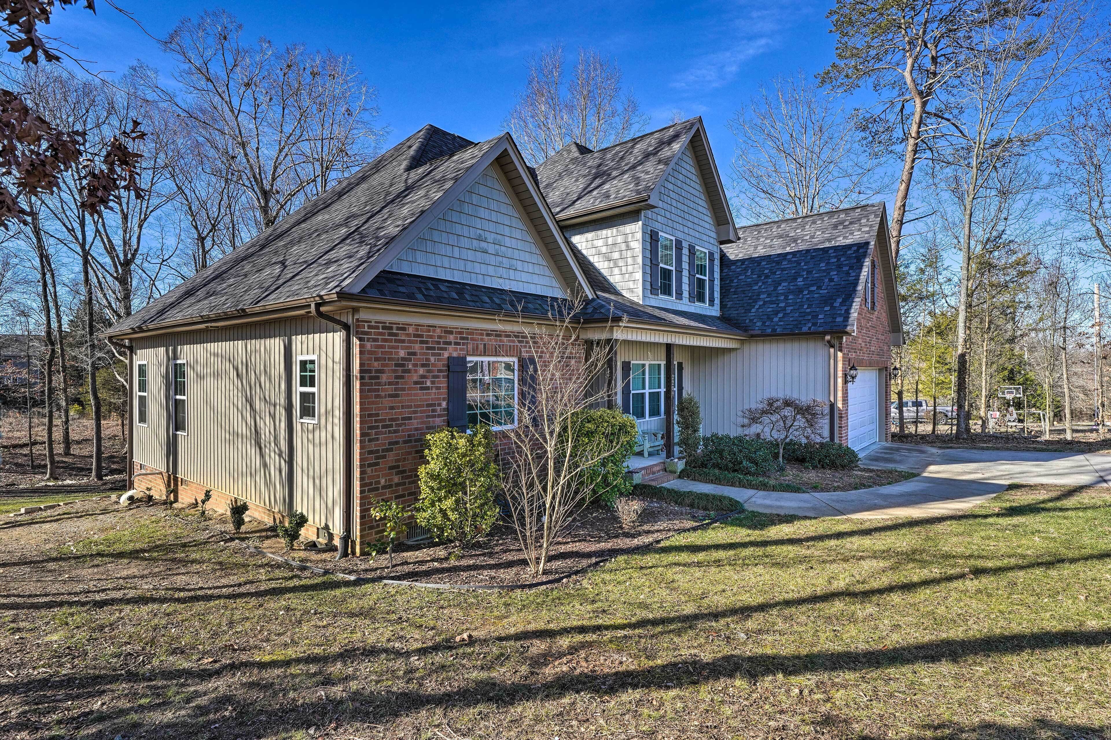 A two-story house with a brick foundation and a gabled roof.
