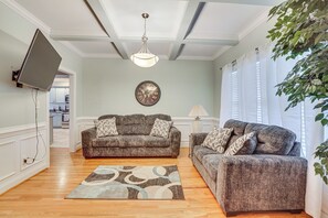 A living room with two grey sofas, a patterned rug, a wall clock, and a ceiling fan. - High Point Home ~ 1 Mi to Oak Hollow Lake! (High Point)