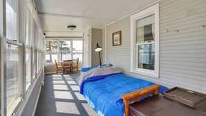 A room with a bed, a chair, a lamp, and a window.