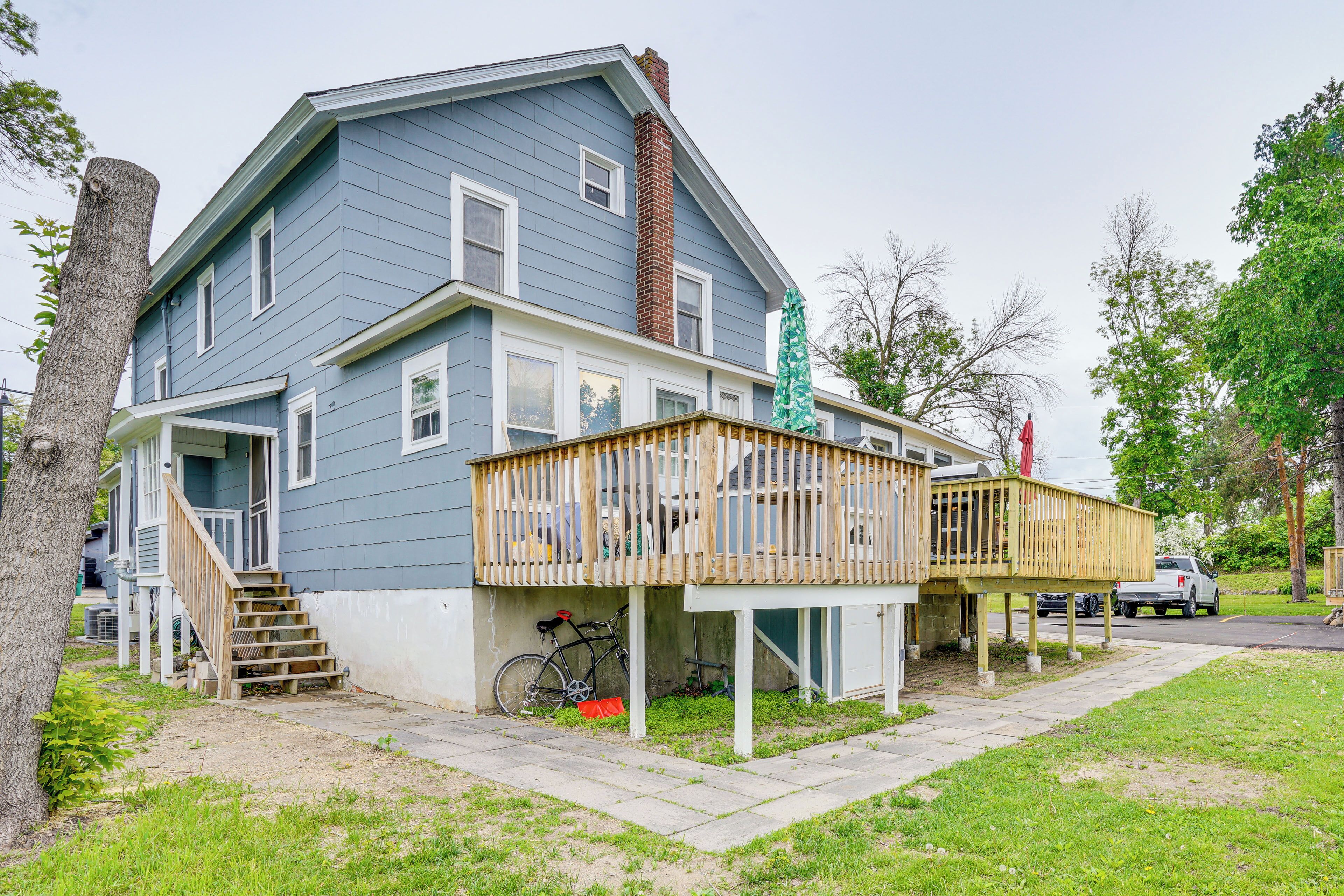 A two-story house with a wooden deck and a bicycle parked outside.