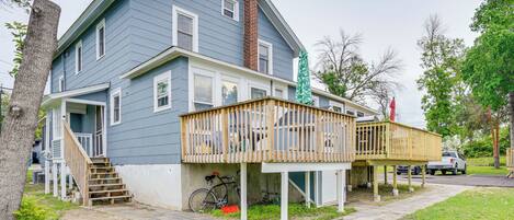 A two-story house with a wooden deck and a bicycle parked outside.