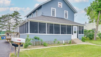 A two-story house with a large front porch and a covered entryway.