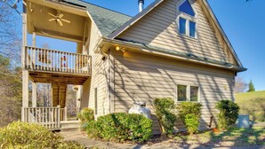 A two-story house with a balcony, a chimney, and a small garden. - Peaceful Lake Lure Cabin w/ Fireplace! (Lake Lure)