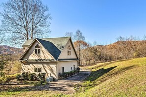 A single-story house with a gabled roof, a front porch, and a driveway leading to the entrance.