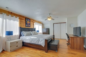 A bedroom with a wooden bed, a nightstand, a desk, a chair, and a ceiling fan. - Alton Cabin w/ Deck ~ 2 Mi to Dixie Nat'l Forest! (Duck Creek Village)