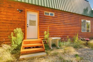 A log cabin with a wooden door, a small window, and a wooden porch.