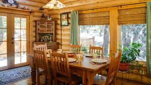A wooden cabin interior with a dining table set for four, surrounded by wooden chairs. - 'lacy's Log Cabin' Alto Home w/ Mountain Views! (Alto)