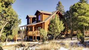 A log cabin with a porch and a deck, surrounded by trees and snow. - 'lacy's Log Cabin' Alto Home w/ Mountain Views! (Alto)