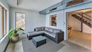 Een moderne woonkamer met een modulaire bank, een salontafel en een potplant.
