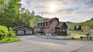 A two-story house with a garage, surrounded by a driveway and a small garden. - 'loretta' Sun-kissed Apt on Country Music Hwy (Hagerhill)