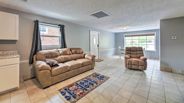 A living room with a beige sofa, a matching armchair, and a patterned rug. - 'loretta' Sun-kissed Apt on Country Music Hwy (Hagerhill)