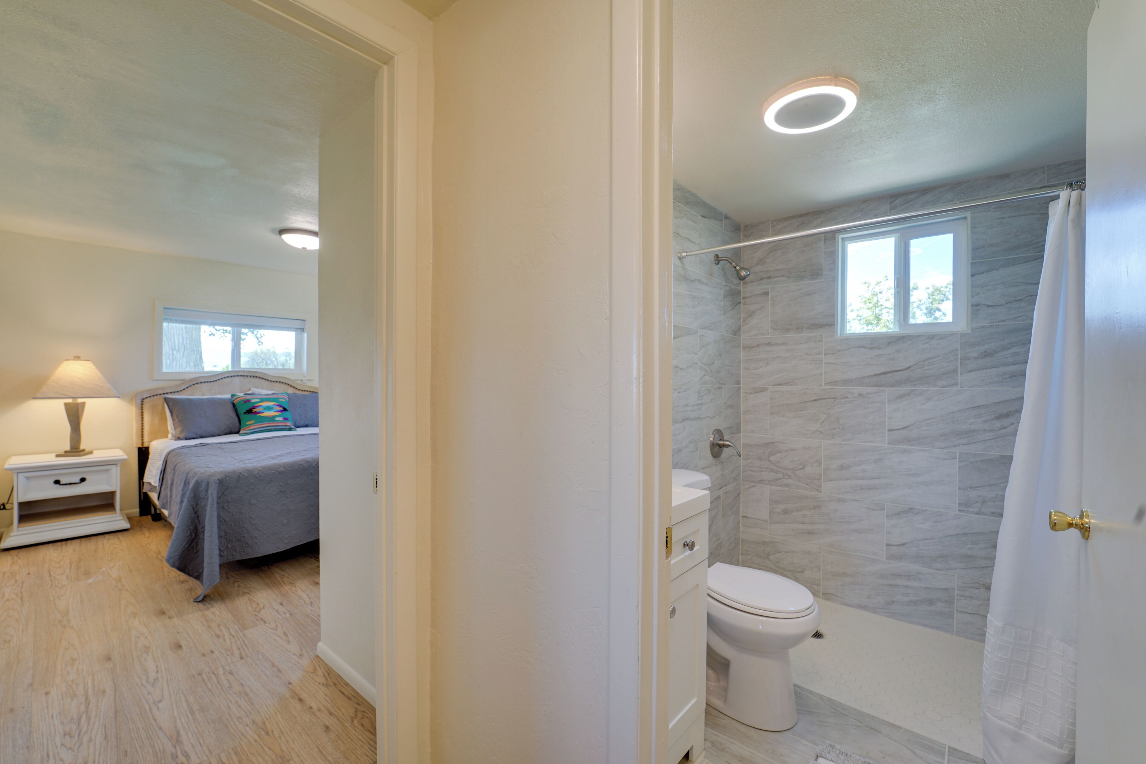 Un baño moderno con ducha, inodoro y ventana.