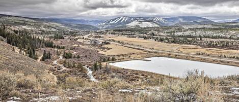 Un paysage montagneux avec un lac, des zones boisées et un petit village.