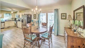 A spacious kitchen with wooden cabinets, a central island, and a chandelier. - Oak Island Home w/ Yard < 1 Mi to the Beach! (Oak Island)