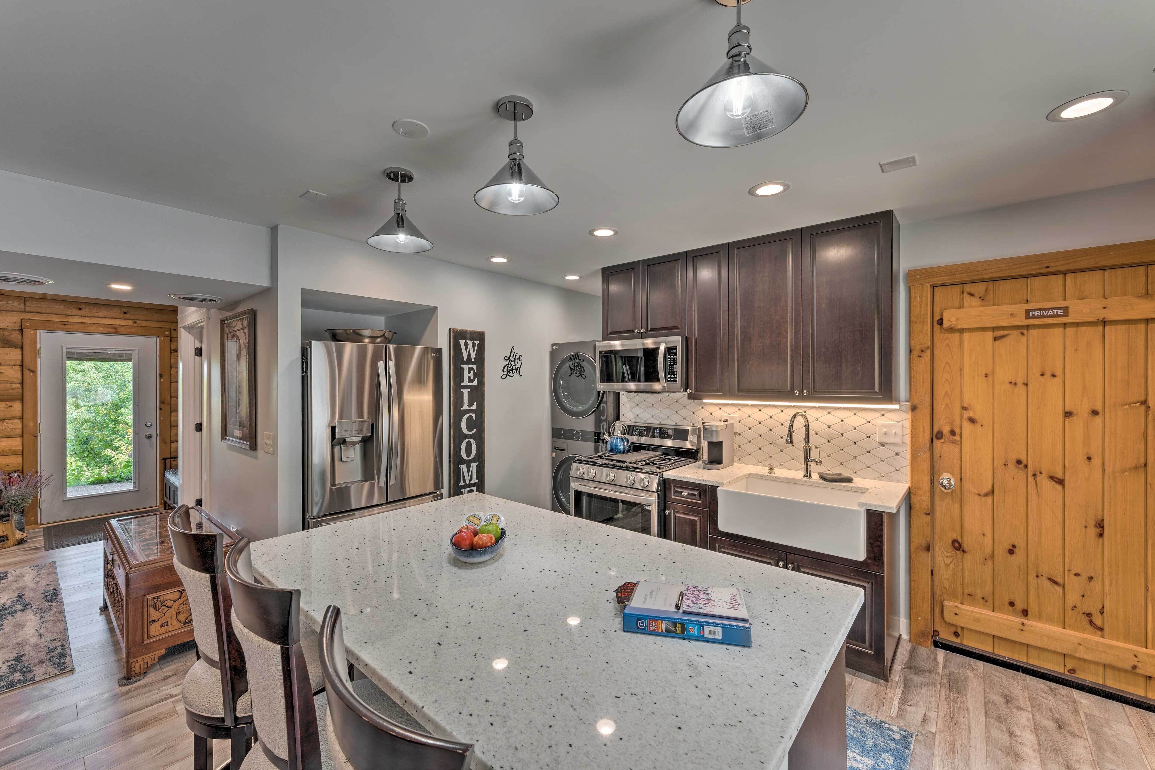 A modern kitchen with stainless steel appliances, a granite island, and a wooden door labeled "PRIVATE".