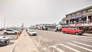 A street with parked cars, a casino building, and a van. - No-frills Hampton Cottage - Steps to Beach! (Hampton)