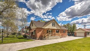 A two-story house with a front porch, a garage, and a well-maintained lawn. - Panguitch Home w/ Patio ~ 24 Mi to Bryce Canyon (Panguitch)
