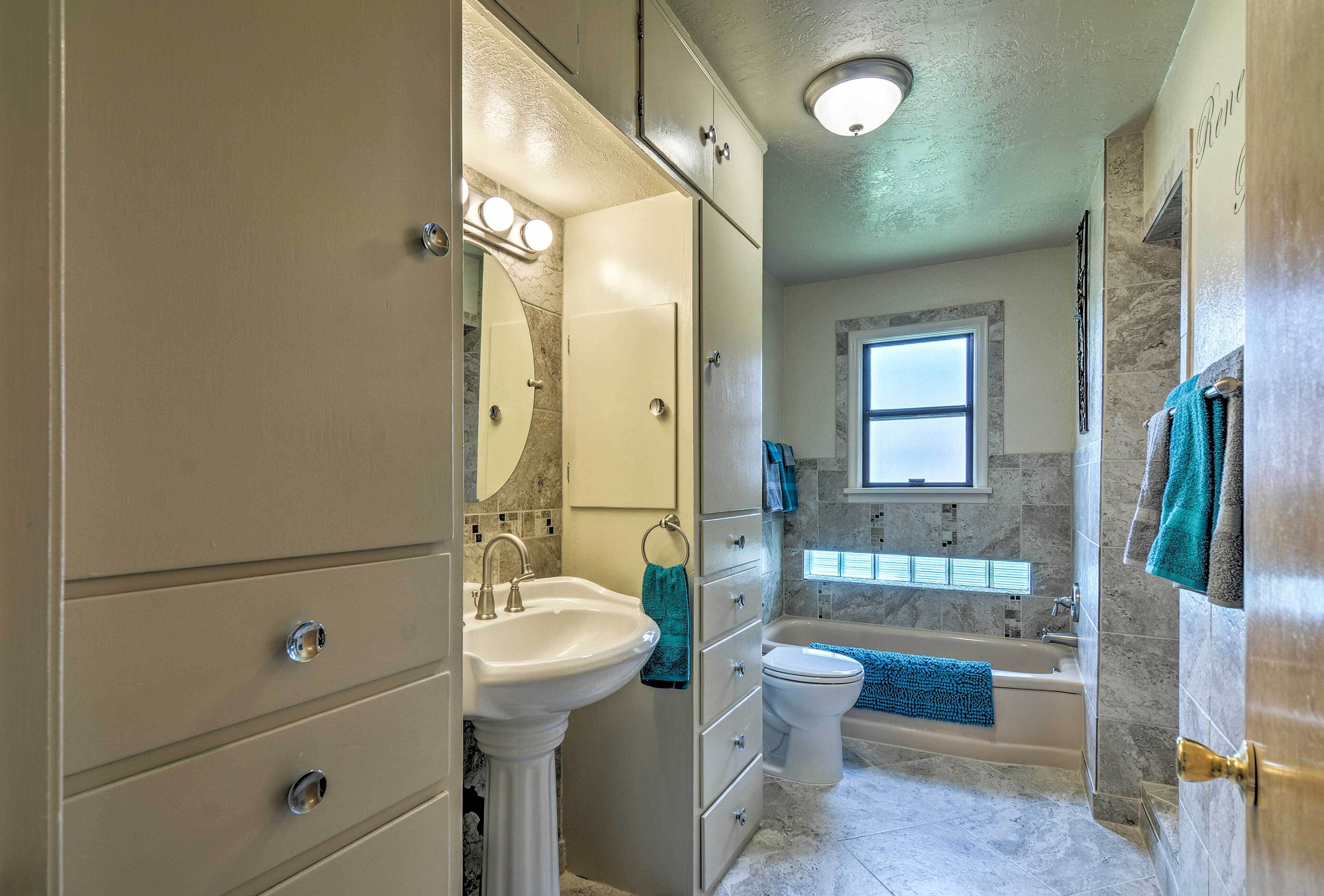 A bathroom with a sink, toilet, and bathtub.