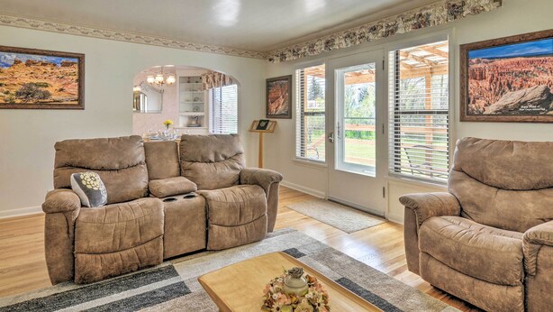 A living room with two brown recliner sofas, a wooden coffee table, and a large window with blinds. - Panguitch Home w/ Patio ~ 24 Mi to Bryce Canyon (Panguitch)