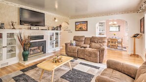 A living room with a fireplace, a television, and a sofa. - Panguitch Home w/ Patio ~ 24 Mi to Bryce Canyon (Panguitch)