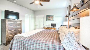 A bedroom with a bed, dresser, ceiling fan, and a desk with a computer. - Magnificent Gypsum Retreat on the Colorado River! (Gypsum)