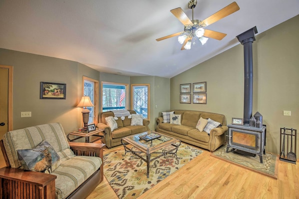 A cozy living room with two sofas, a coffee table, a fireplace, and a ceiling fan. - Montana Home on 5 Acres: Near Lake Koocanusa! (Rexford)