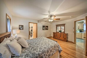 A bedroom with a bed, a dresser, a ceiling fan, and a door leading to a bathroom. - Montana Home on 5 Acres: Near Lake Koocanusa! (Rexford)
