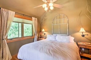 A bedroom with a large bed, two bedside lamps, a ceiling fan, and a window with curtains. - Peaceful Marble, Colorado Home w/ Deck & Mtn Views (Carbondale)