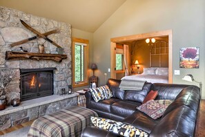 A cozy living room with a stone fireplace, leather sofa, and a wooden ceiling. - Peaceful Marble, Colorado Home w/ Deck & Mtn Views (Carbondale)
